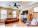 Cozy living room showcasing a fireplace, leather sofa, ceiling fan and hardwood floors at 3354 Wabash St, Denver, CO 80238