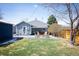 Expansive backyard featuring a patio with outdoor seating, a fire pit, and a lush green lawn at 1794 Xenia St, Denver, CO 80220