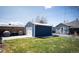 Landscaped backyard featuring a blue shed, concrete patio, green lawn, and string lights at 1794 Xenia St, Denver, CO 80220