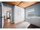 Bright bedroom features a wooden ceiling, hardwood floors, a closet, and a view into the kitchen at 1794 Xenia St, Denver, CO 80220