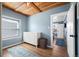 Light-filled bedroom with wood ceiling, hardwood floors, a dresser, and a view into the main bedroom at 1794 Xenia St, Denver, CO 80220