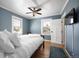 Bright bedroom with two windows, blue walls, hardwood floors, and a comfortable bed with white linens at 1794 Xenia St, Denver, CO 80220