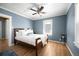 Cozy bedroom featuring hardwood floors, blue walls, ceiling fan, and a comfortable bed with white linens at 1794 Xenia St, Denver, CO 80220