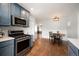 Stylish kitchen featuring stainless steel appliances, blue cabinets, and a charming dining area at 1794 Xenia St, Denver, CO 80220