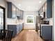 Well-lit kitchen featuring stainless steel appliances, blue cabinets, and hardwood floors at 1794 Xenia St, Denver, CO 80220