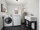 Practical laundry room with modern washer, dryer, utility sink, and black tiled floors at 1794 Xenia St, Denver, CO 80220