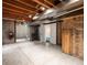 Unfinished basement with exposed ceiling, concrete floor, and double door access for customization and ample storage at 11254 Oakland Dr, Commerce City, CO 80640