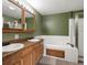 Bathroom featuring double sinks with cabinet storage and a shower/tub combo at 11254 Oakland Dr, Commerce City, CO 80640