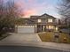 Charming two-story home featuring an attached two-car garage, inviting porch, and manicured front lawn at 11254 Oakland Dr, Commerce City, CO 80640