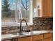 Updated kitchen featuring stainless steel sink, granite countertops, and a view of the backyard at 11254 Oakland Dr, Commerce City, CO 80640