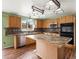Well-equipped kitchen featuring wood cabinets, an island, stainless steel appliances, and granite countertops at 11254 Oakland Dr, Commerce City, CO 80640