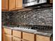 Kitchen area with stainless steel appliances, tile backsplash, granite countertops, and light wood cabinets at 11254 Oakland Dr, Commerce City, CO 80640