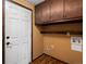 Laundry area features upper cabinets, shelving, and wood flooring at 11254 Oakland Dr, Commerce City, CO 80640
