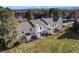 Aerial view of homes with spacious backyards and patios, surrounded by green grass and trees at 3295 S Estes St, Lakewood, CO 80227