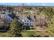 Aerial view of multiple homes in the neighborhood, featuring green lawns, trees, and mountain views at 3295 S Estes St, Lakewood, CO 80227
