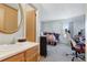 View of bathroom connecting to the bedroom, featuring sink with golden hardware and a wooden cabinet at 3295 S Estes St, Lakewood, CO 80227