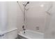 Close-up of the tiled bathtub and shower area, including the toilet, within the bathroom at 3295 S Estes St, Lakewood, CO 80227