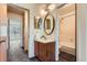 Bathroom with a sink and vanity with wood finish and oval mirror at 3295 S Estes St, Lakewood, CO 80227