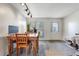 Bright dining area with wood table, large window, and modern track lighting at 3295 S Estes St, Lakewood, CO 80227