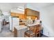 Cozy kitchen featuring wood cabinets, white appliances, and a breakfast bar at 3295 S Estes St, Lakewood, CO 80227