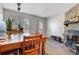 Open-concept living room, stone fireplace, dining area, and natural lighting at 3295 S Estes St, Lakewood, CO 80227