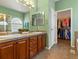 Bathroom with double sink vanity, large mirror, and walk in closet at 22647 Hopewell Ave, Parker, CO 80138