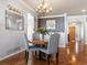 Elegant dining room with hardwood floors, modern chandelier, view to living room and front entryway at 22647 Hopewell Ave, Parker, CO 80138