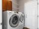 Modern laundry room equipped with front load washer and dryer, plus storage cabinets at 22647 Hopewell Ave, Parker, CO 80138