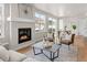 Bright living room with hardwood floors, large windows, and a cozy fireplace at 4888 Noris Ave, Morrison, CO 80465