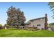 Well-manicured backyard features a lawn, flower garden, mature tree, and a wood deck perfect for outdoor entertaining at 13123 Spica Dr, Lone Tree, CO 80124