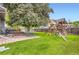 Backyard featuring green grass, a large tree, a playset, and patio set at 13123 Spica Dr, Lone Tree, CO 80124