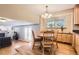 Open dining area with wood floors, chandelier, natural light, and access to the living area at 13123 Spica Dr, Lone Tree, CO 80124