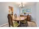 Cozy dining room with wood table, carpet, chandelier, and large window at 13123 Spica Dr, Lone Tree, CO 80124
