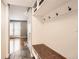 Hallway area with wooden bench, coat hooks and view to living room with hardwood floors at 13123 Spica Dr, Lone Tree, CO 80124