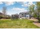 Large backyard featuring a well-maintained lawn, patio, trampoline, and exterior view of the home at 26404 E Caley Dr, Aurora, CO 80016