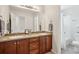 Bathroom featuring double sink vanity, wood cabinets, and shower at 26404 E Caley Dr, Aurora, CO 80016