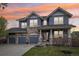 Charming two-story home with a stone and siding exterior, well-manicured lawn, and three-car garage at 26404 E Caley Dr, Aurora, CO 80016