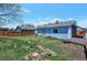 Backyard landscape with grass, stepping stones, and a view of the back of the blue house at 1451 S Quitman St, Denver, CO 80219