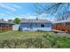 Spacious backyard with a well-maintained lawn, wooden fence, and small storage shed at 1451 S Quitman St, Denver, CO 80219