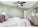 Inviting bedroom with light green walls, wood floors, and a comfortable bed beneath a ceiling fan at 1451 S Quitman St, Denver, CO 80219