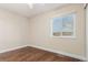 Simple bedroom with natural light, wood floors, and a window view of the exterior at 1451 S Quitman St, Denver, CO 80219