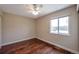 Neutral bedroom with hardwood floors, ceiling fan, and a bright window overlooking the backyard at 1451 S Quitman St, Denver, CO 80219