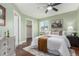 Charming bedroom featuring a ceiling fan, window, accent wall, and stylish furnishings for a relaxing ambiance at 1451 S Quitman St, Denver, CO 80219
