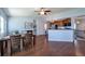 Open-concept living features wood floors, fireplace and adjacent kitchen with breakfast bar at 1451 S Quitman St, Denver, CO 80219