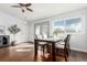 Sunlit dining area with warm hardwood floors, a view to the yard, and a quaint tree accenting the space at 1451 S Quitman St, Denver, CO 80219