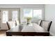 Bright dining room with a large window, dark wooden table with 6 chairs, and an exterior door at 1451 S Quitman St, Denver, CO 80219