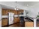 Kitchen with stainless steel appliances, wood cabinets, and a view of the dining area at 1451 S Quitman St, Denver, CO 80219