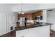 Kitchen features stainless steel appliances, wood cabinetry, and a view into the dining area at 1451 S Quitman St, Denver, CO 80219