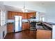 Open kitchen with sleek stainless steel appliances, granite counters and hardwood floors at 1451 S Quitman St, Denver, CO 80219
