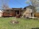 A house's backyard has a small deck, a lawn, and is surrounded by lush greenery at 4060 Shaw Blvd, Westminster, CO 80031